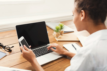 Poster - Back view of young woman using laptop with blank screen