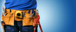 closeup of handyman tool belt on blue background with copy space