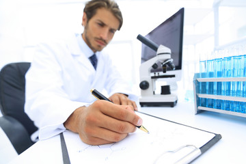 Wall Mural - scientist makes a note of experiment in the laboratory