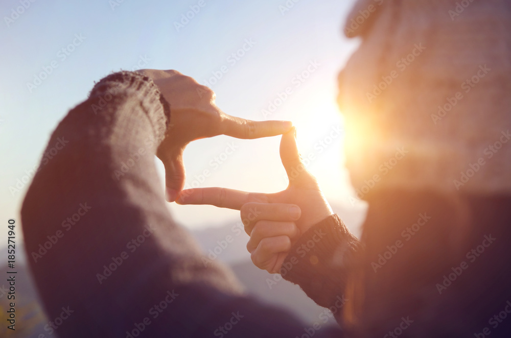 Close up of woman hands making frame gesture with sunrise on moutain, Female capturing the sunrise, Future planning, sunlight outdoor. - obrazy, fototapety, plakaty 