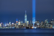 The two beams of the Tribute in Light with skycrapers of Lower Manhattan at night from New York Harbor. Financial District, New York City