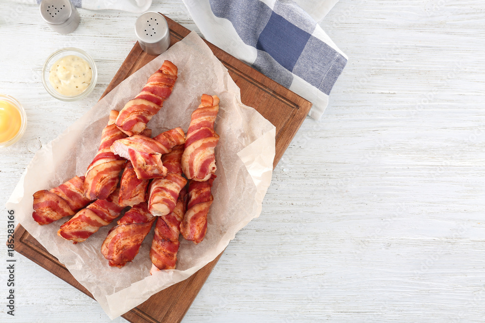 Bacon wrapped chicken nuggets on wooden board