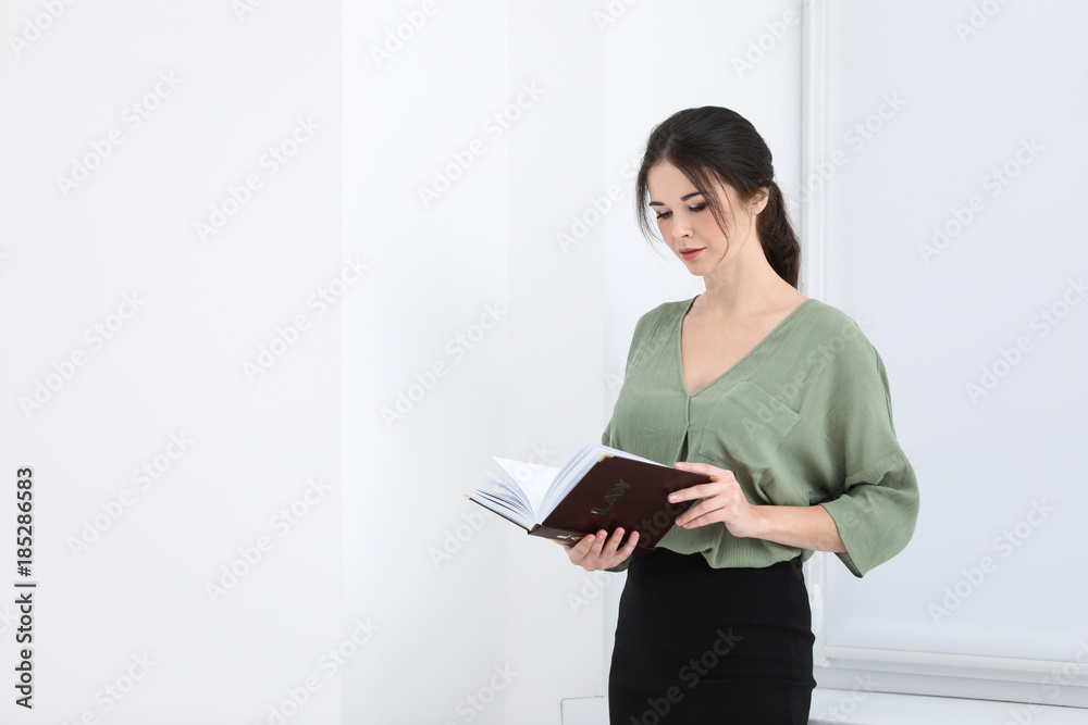 Young female notary with book indoors
