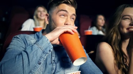 Poster - Cheerful concentrated youngers in 3d glasses watching film with popcorn in cinema
