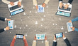 © adam121 - Top view of businesspeople sitting at table and using gadgets