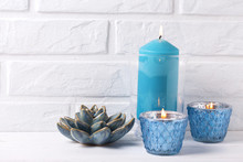Blue Burning Candles Near By White Brick Wall.