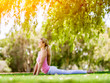 © Sergey Nivens - Young woman doing yoga in the park