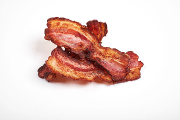 Three cooked, crispy fried bacon isolated on a white background.