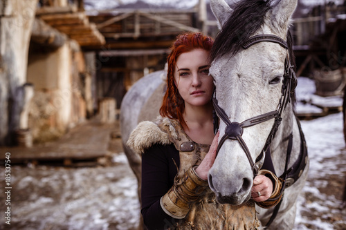 Fotografie, Obraz Viking woman with hammer in a traditional warrior clothes.