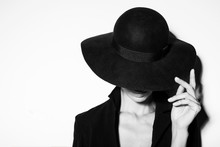 High Fashion Portrait Of Elegant Woman In Black And White Hat And Dress. Studio Shot