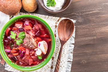 Wall Mural - Bowl of borscht top view with copy space. Sour soup with beetroots, cabbage and beef. National Russian and Ukrainian dish. 