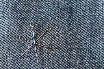 Texture of vintage blue jeans background and pins