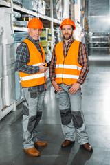 Wall Mural - two male workers holding walkie talkie in shipping stock