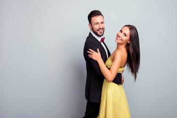 Poster - Portrait with copy space of love story of cute, cheerful, attractive, sexy couple in elegant outfit, tux, hugging, dancing, looking at camera, standing over grey background on party