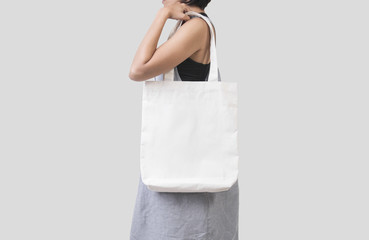 girl is holding bag canvas fabric for mockup blank template isolated on gray background.