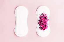 Two Menstrual Pads With Red Glitter On Pastel Pink Colored Background. Minimalist Still Life Photography Concept