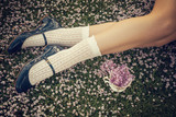 Fototapeta Konie - Girl legs lying on the grass with a fine bone china teacup and a bouquet of lilac flowers - Spring flowers - Shabby chic blossom
