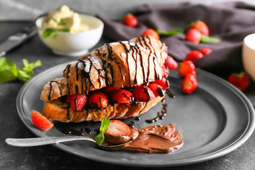 Wall Mural - Delicious croissant with strawberries and chocolate syrup on plate