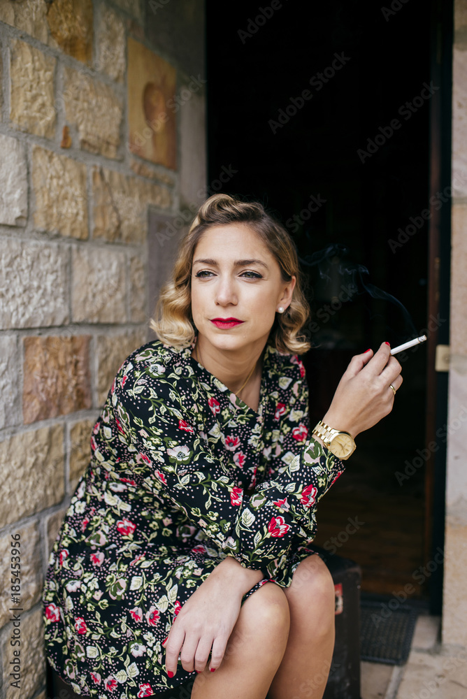 pretty woman smoking cigarette Pretty woman smoking on porch Stock Photo