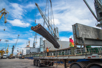 Wall Mural - steel rod carry on lifting by the ship’s crane and lifting gears shackles, hooks, wire sling rope and chains with spreader bar, working with labor stevedore on port terminal