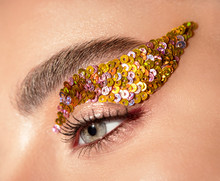 Woman Eye With Yellow Sequins Makeup Closeup