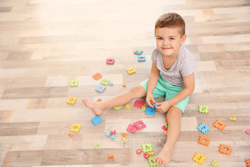 cute little boy playing with math puzzle at home