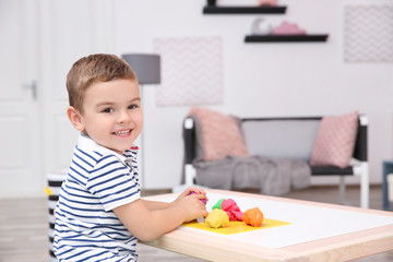 Canvas Print - Cute little boy modeling from playdough at home