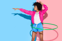 Sporty Woman Posing While Exersizing With Hoop On Pink And Blue Background