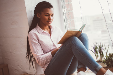 Concentrated African woman reading book