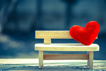 Wall Mural - red heart on wooden bench with dramatic tone