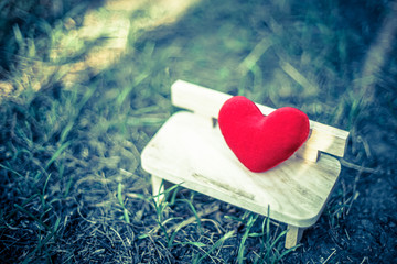 Wall Mural - red heart on wooden bench with dramatic tone