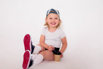 little girl in a sports style with a coffee glass in her hand