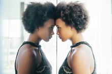 Young Woman Looking At Reflection In Mirror