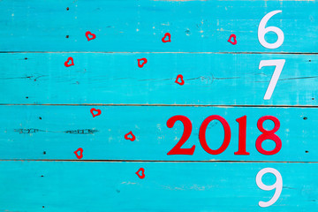 Wall Mural - Year 2018 between 2016, 2017, and 2019 with red hearts on antique teal blue wood background; holiday sign with copy space