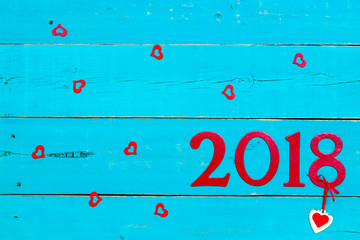 Wall Mural - Year 2018 in bold red with hearts hanging on antique rustic teal blue background; blank holiday sign