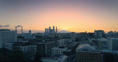 Aufkleber - Ascending over rooftops, revealing aerial panorama Moscow city skyline at sunset