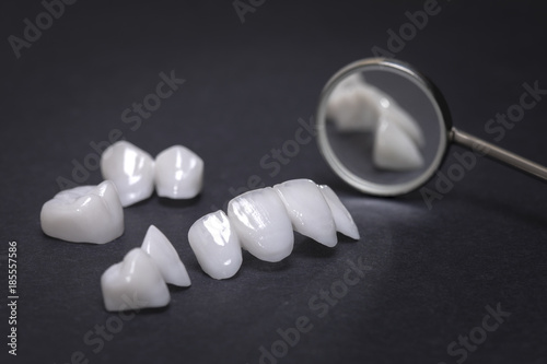Fotografering Dental mirror and zircon dentures on a dark background - Ceramic veneers - lumin