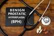 BENIGN PROSTATIC HYPERPLASIA (BPH) or prostate enlargement. Stethoscope and medication on wooden table.