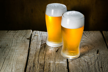 Canvas Print - Beer in frosty mugs on rustic background