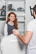 © LIGHTFIELD STUDIOS - dry cleaning manager carrying bags of clothes for woman