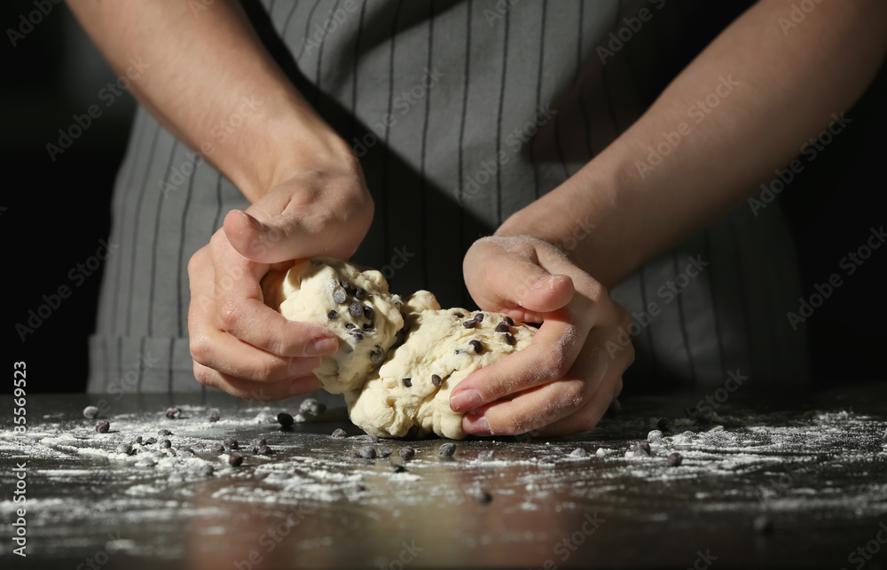 Woman kneading dough on table
