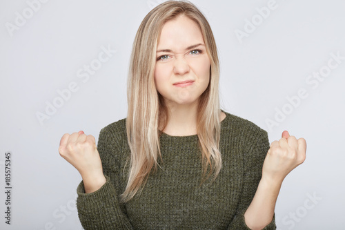 Fotografía Studio shot of annoyed irritated angry woman keeping teeth clenched, her grimace and gesture expressing fury and madness