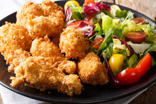 Deep-fried Chicken Wings In Breadcrumbs And Fresh Vegetable Close-up. Horizontal