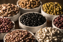 Assorted Beans In Bowls On Wood Background