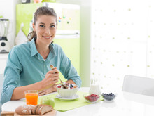 Smiling Woman Having Breakfast At Home