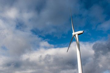 Isolated Silhouette of windturbine energy generator on blue cloudy sky at a wind farm in germany