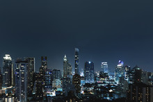 City Scape Over Night Sky. Groups Of Tall Commercial Building On Night Sky In Background.