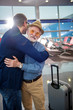 © Yakobchuk Olena - Sweet bonding. Pleasant elderly bearded father and his adult son are standing at international airport. They are hugging while feeling happiness. Back view of guy
