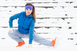 Woman wearing sportswear exercising outside during winter