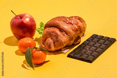 Fotografie, Tablou The apple, chocolate and croissants on yellow background
